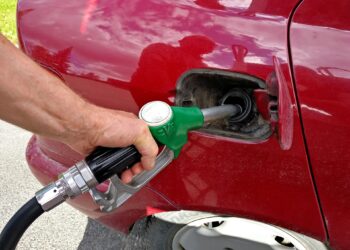 Bico de combustível inserido no tanque de um automóvel durante abastecimento em posto
