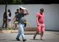 Pedestres caminham sob sol forte em São Paulo durante período de calor e baixa umidade