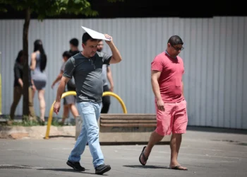 Pedestres caminham sob sol forte em São Paulo durante período de calor e baixa umidade