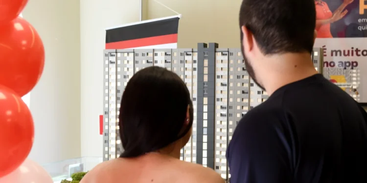 Casal observa maquete de empreendimento habitacional durante ação do Casa Paulista