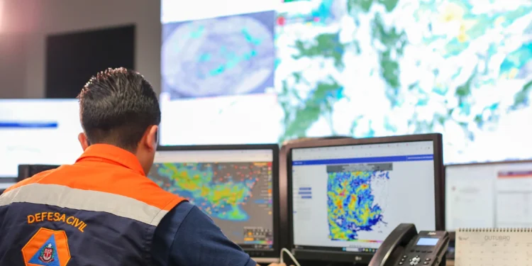 Agente da Defesa Civil de São Paulo monitora condições meteorológicas em sala de operações