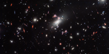 Campo de galáxias do aglomerado MACS J0417, que produz efeito de lente gravitacional
