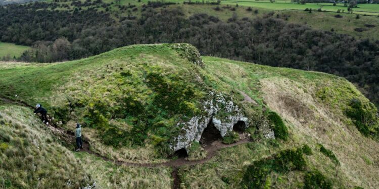 Entrada de caverna cercada por vegetação, imagem ilustrativa para matéria sobre trilhas e cavernas em parque nacional