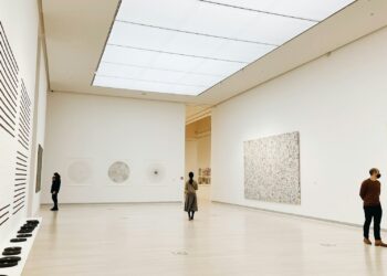 Visitantes observando obras de arte em uma galeria de museu