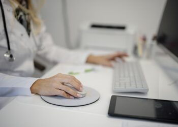 Profissional de saúde utiliza computador em consultório, imagem ilustrativa de serviços digitais